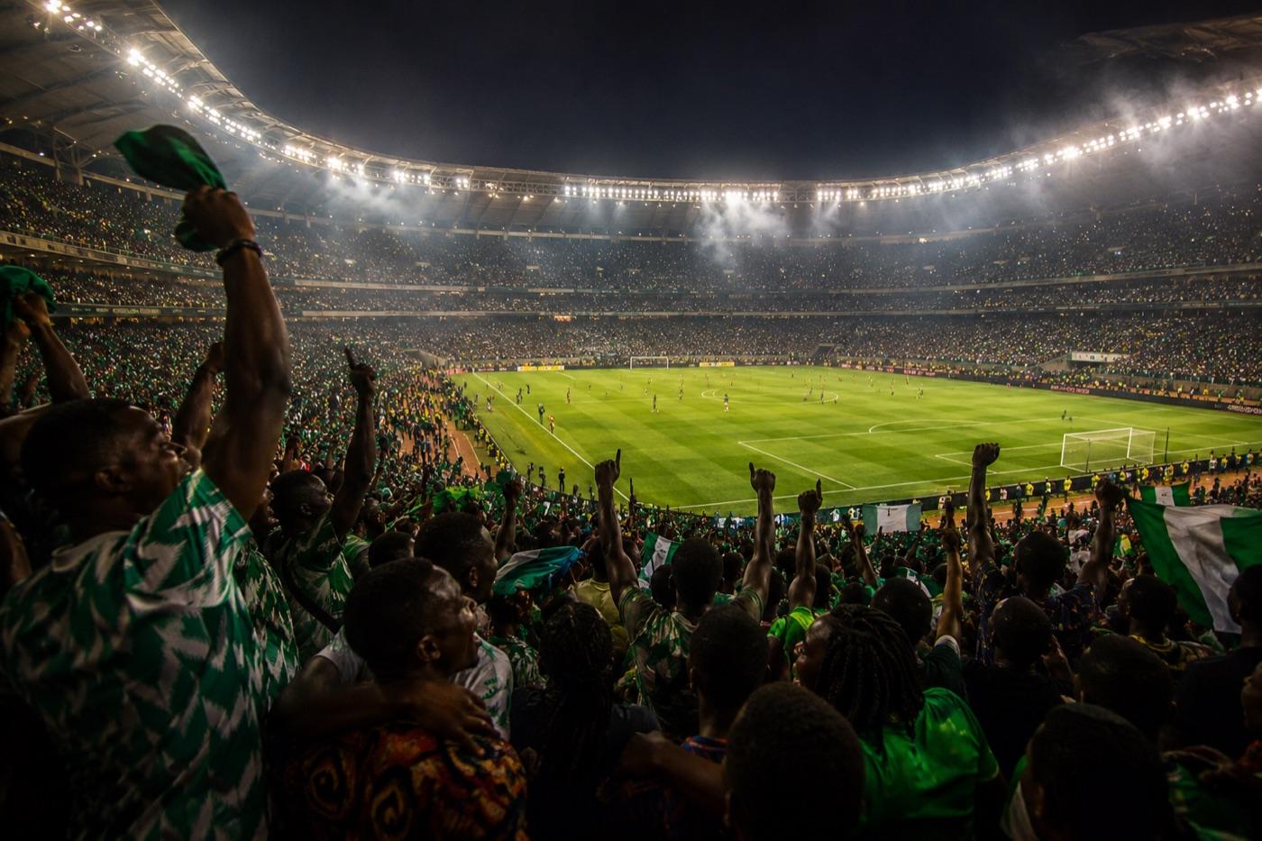 Nigerian football fans in green and white celebrating in a packed stadium, reflecting Bet9ja's deep NPFL coverage